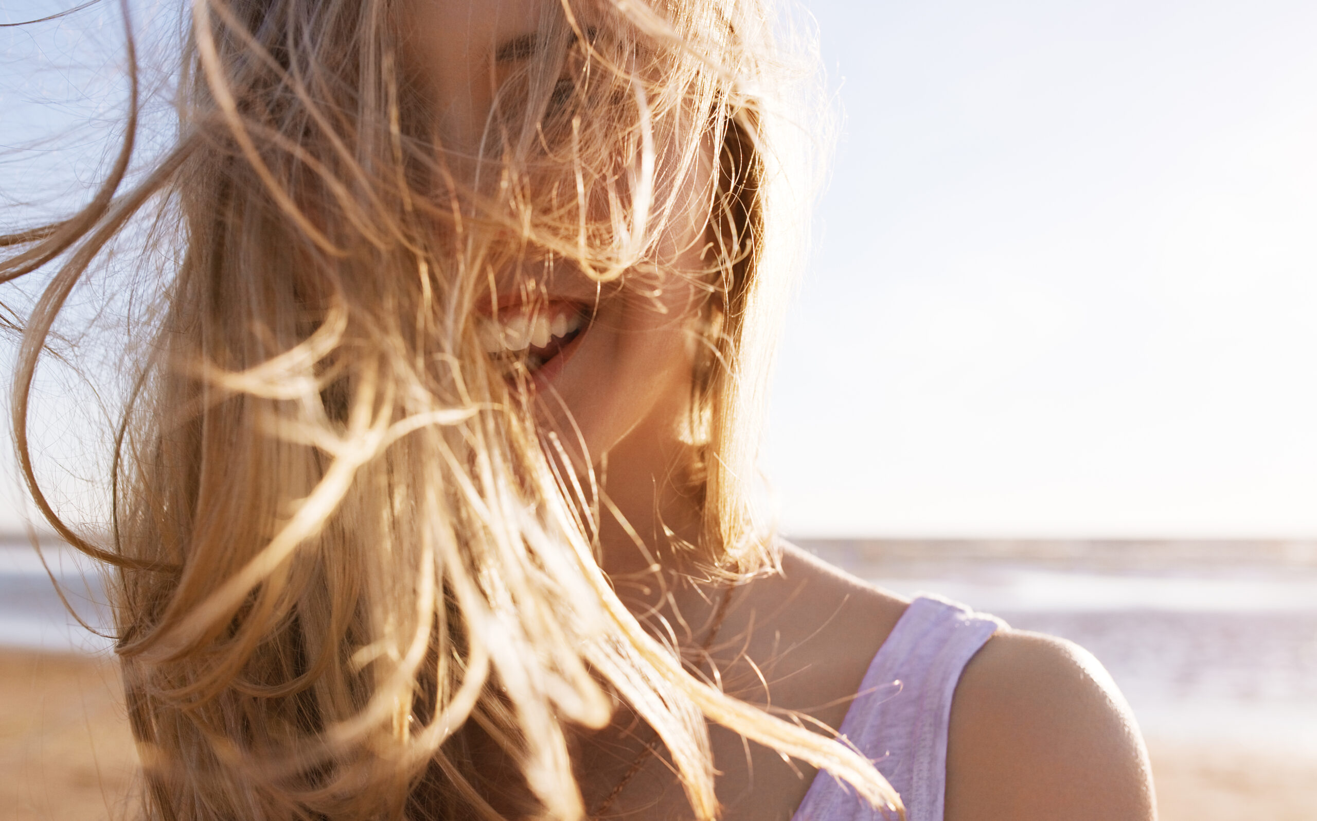 Une femme qui rit devant une plage